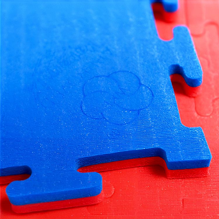 Close view of two embossed mat tiles locked together along their dovetail interlocking edges, with the joint seam running across the frame